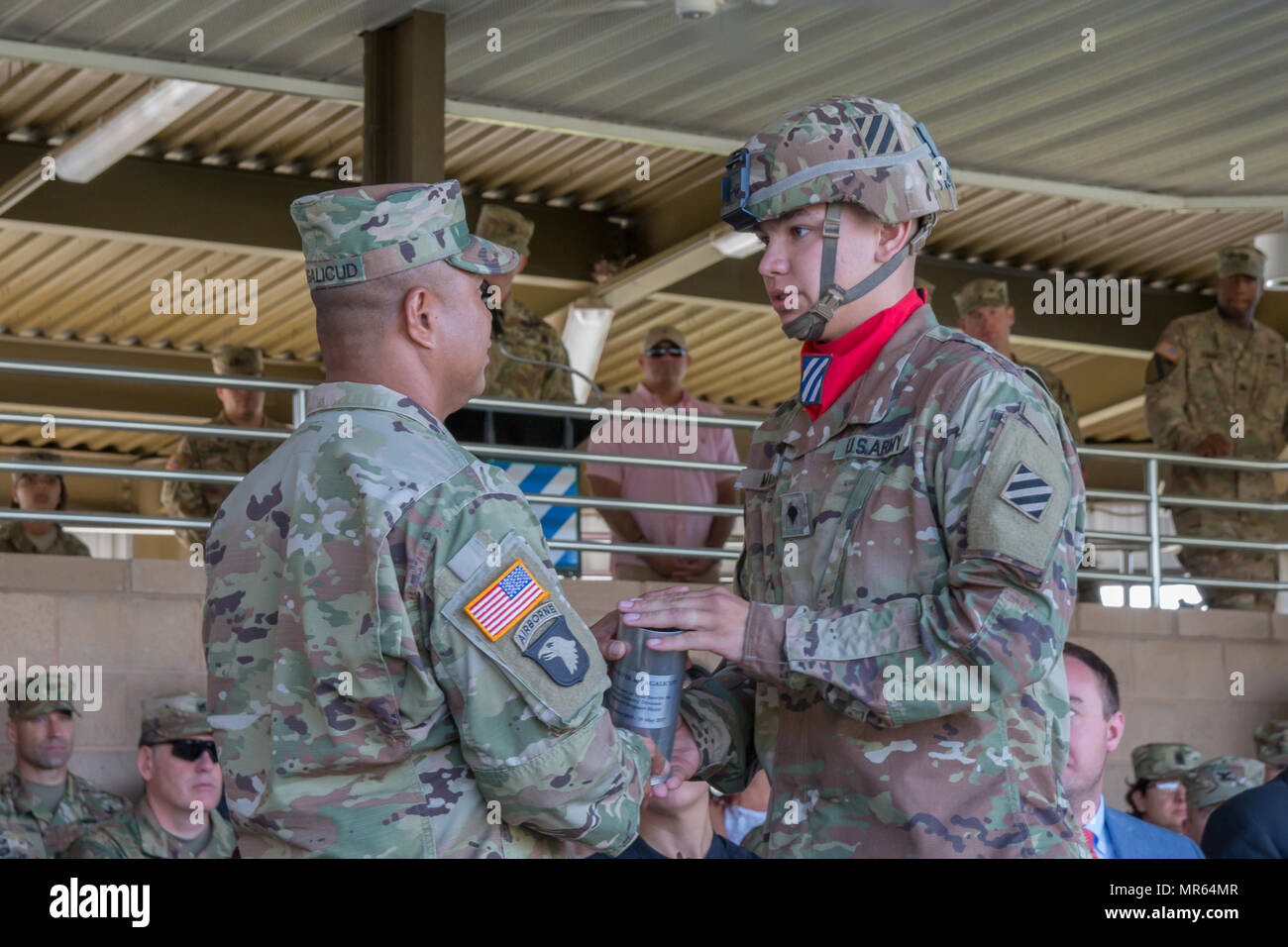 A 3rd Infantry Division artilleryman presents a howitzer shell to ...