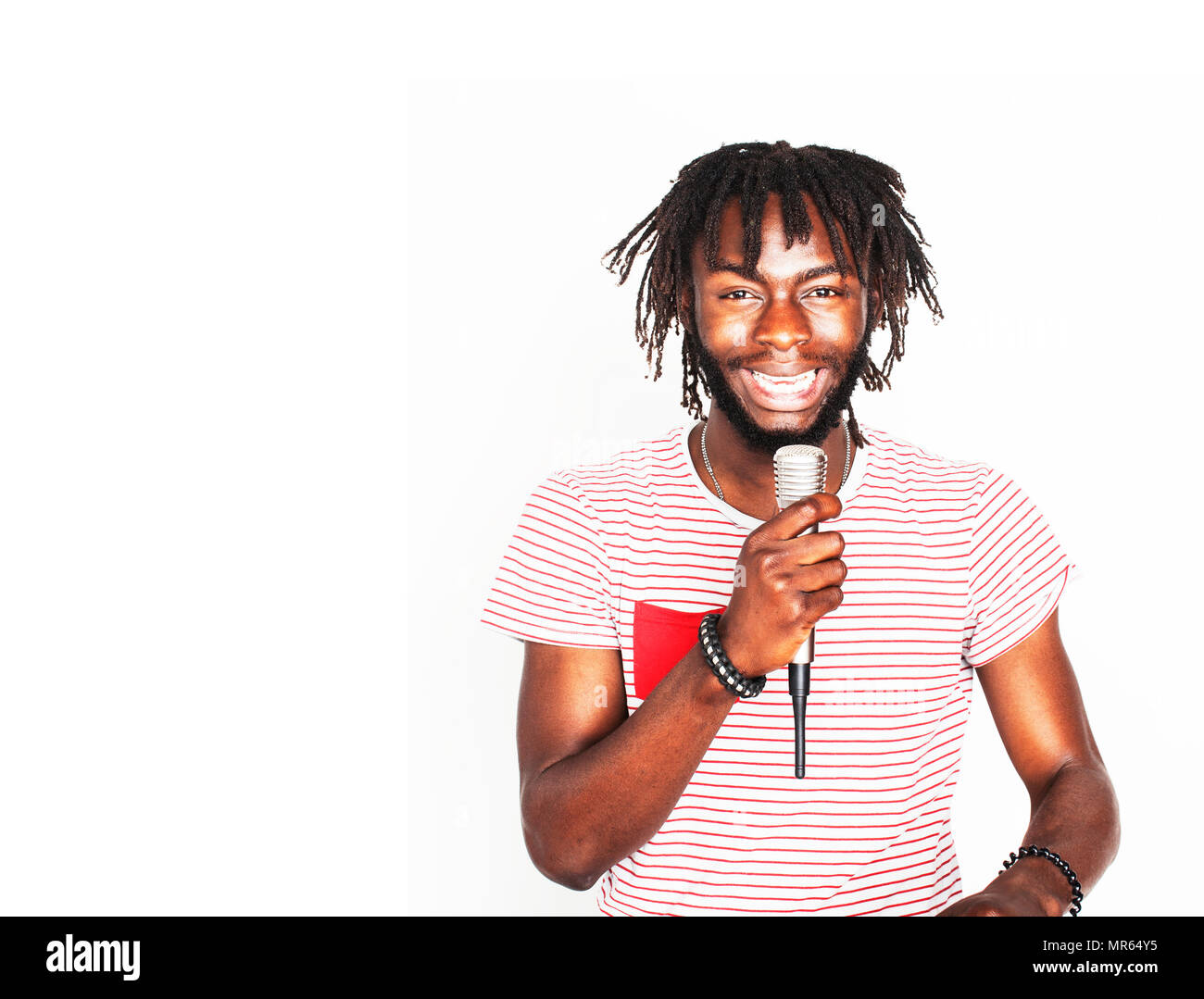 young handsome african american boy singing emotional with microphone isolated on white background, in motion gesturing smiling, lifestyle people conc Stock Photo