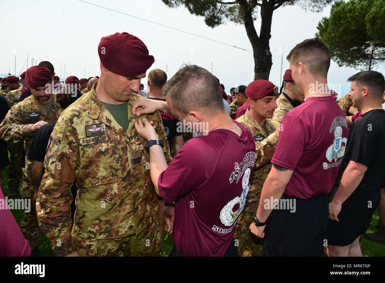 U.S. Army Paratroopers assigned to 1st Battalion, 503rd Infantry Regiment, 173rd Airborne Brigade, Italian Army Paratroopers from the 4th Regimento Paracadutisti Alpini and the Brigata Folgore exchange airborne wings after a water jump into Lake Garda near Pacengo, Italy, May 18, 2017. The event highlighted combined NATO airborne operations between the brigade and its host nation allies. The 173rd Airborne Brigade is the U.S. Army Contingency Response Force in Europe, capable of projecting ready forces anywhere in the U.S. European, Africa or Central Commands' areas of responsibility within 18 Stock Photo