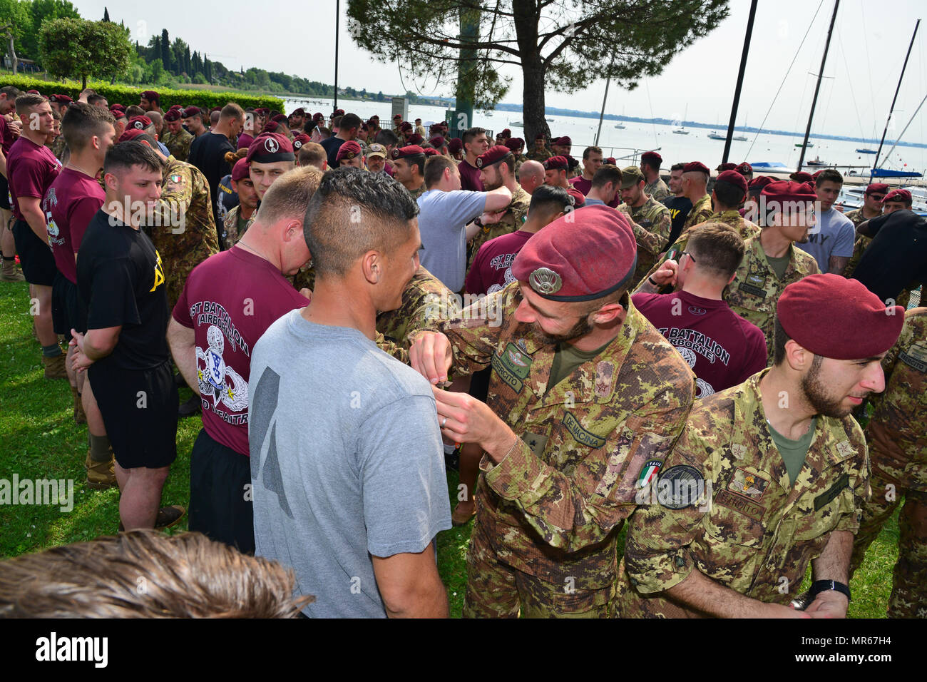 U.S. Army Paratroopers assigned to 1st Battalion, 503rd Infantry Regiment, 173rd Airborne Brigade, Italian Army Paratroopers from the 4th Regimento Paracadutisti Alpini and the Brigata Folgore exchange airborne wings after a water jump into Lake Garda near Pacengo, Italy, May 18, 2017. The event highlighted combined NATO airborne operations between the brigade and its host nation allies. The 173rd Airborne Brigade is the U.S. Army Contingency Response Force in Europe, capable of projecting ready forces anywhere in the U.S. European, Africa or Central Commands' areas of responsibility within 18 Stock Photo