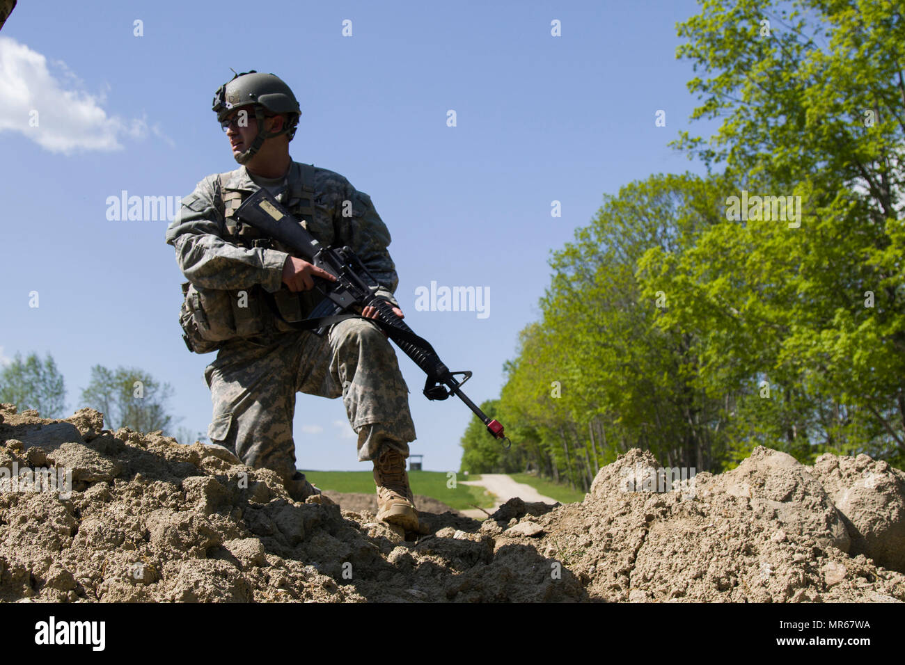 A U.S. Army officer candidate observes soldiers clearing a make-shift bunker during a bunker clearing lane at New Hampshire National Guard Training Site in Center Strafford, Nh., May 19, 2017. Soldiers from Connecticut, Maine, Massachusetts, New Hampshire, New Jersey, New York, Rhode Island, and Vermont participated in the Officer Candidate School Field Leadership Exercise in preparation for graduation and commission. (U.S. Army National Guard photo by Spc. Avery Cunningham) Stock Photo