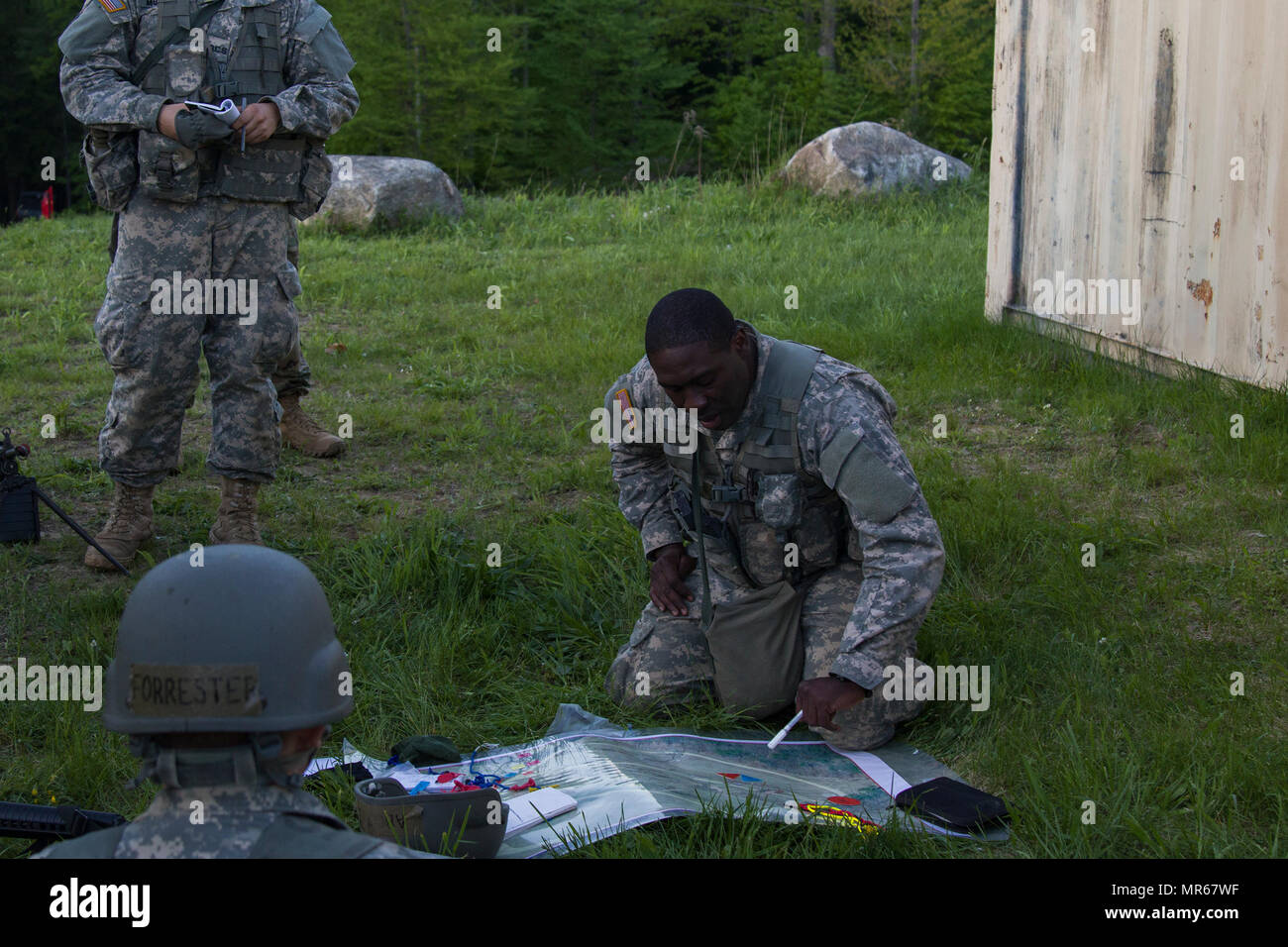 U.S. Army Officer Candidate Isaac Abotsi, with Hotel Company, 2nd Modular Training Battalion, 124th Regiment (Regional Training Institute), Vermont National Guard, delivers an operations order to his squad during an enter and clear a building lane at New Hampshire National Guard Training Site in Center Strafford, Nh., May 19, 2017. Soldiers from Connecticut, Maine, Massachusetts, New Hampshire, New Jersey, New York, Rhode Island, and Vermont participated in the Officer Candidate School Field Leadership Exercise in preparation for graduation and commission. (U.S. Army National Guard photo by Sp Stock Photo