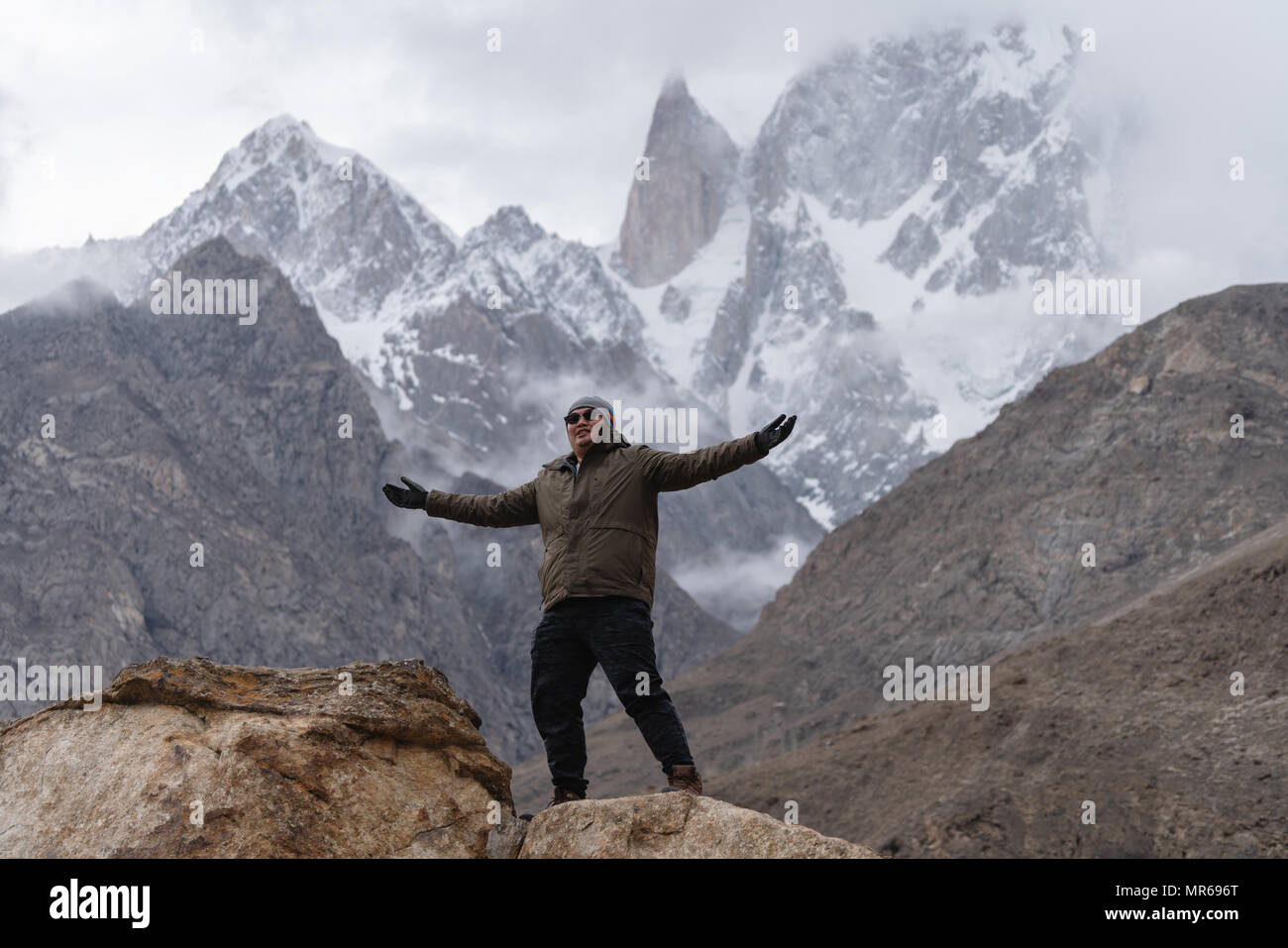 a man raising hand up on the mountain peak and Ladyfinger mountain peak background, in Pakistan Stock Photo