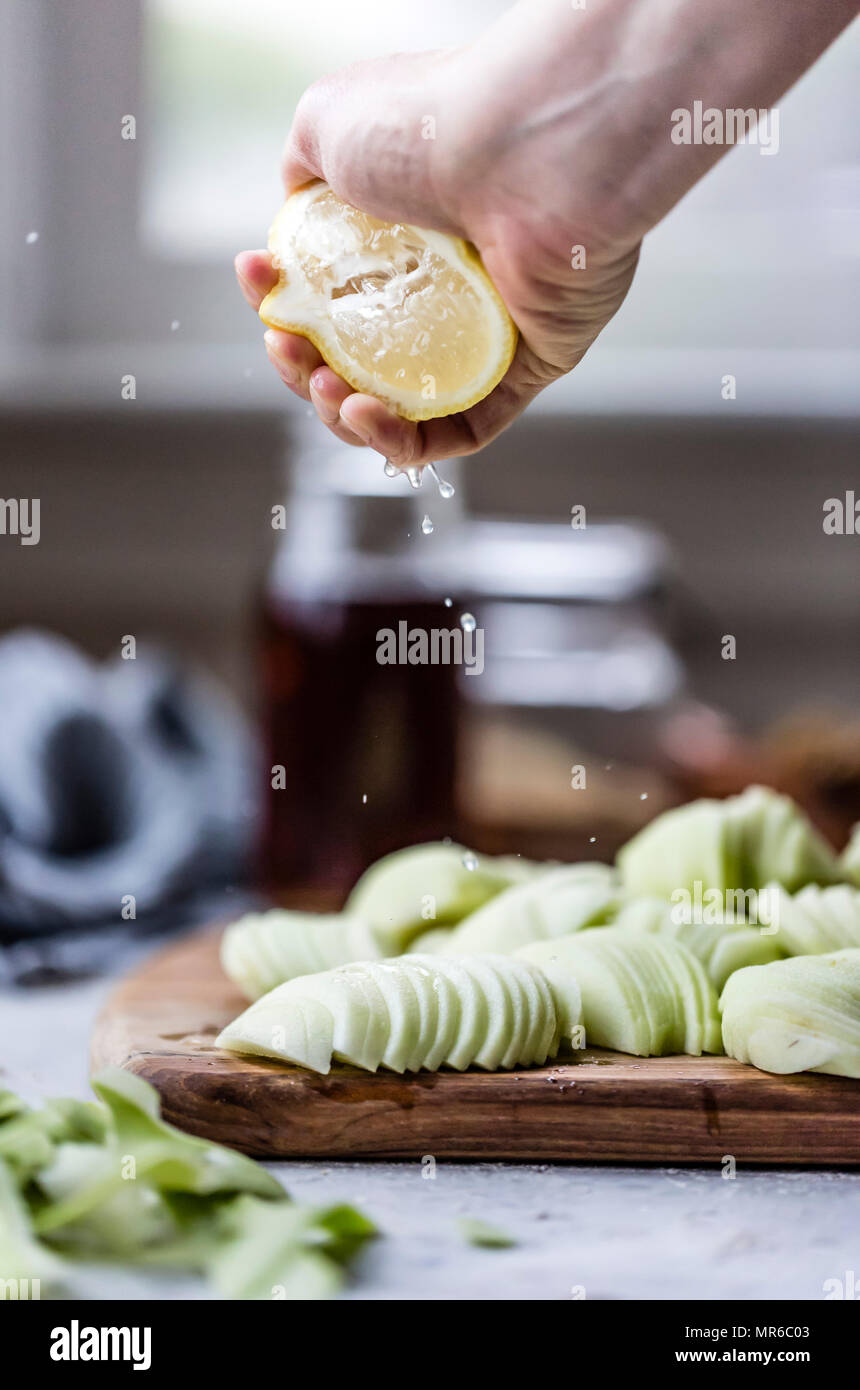 Squeezing lemon juice over freshly peeled apples Stock Photo Alamy