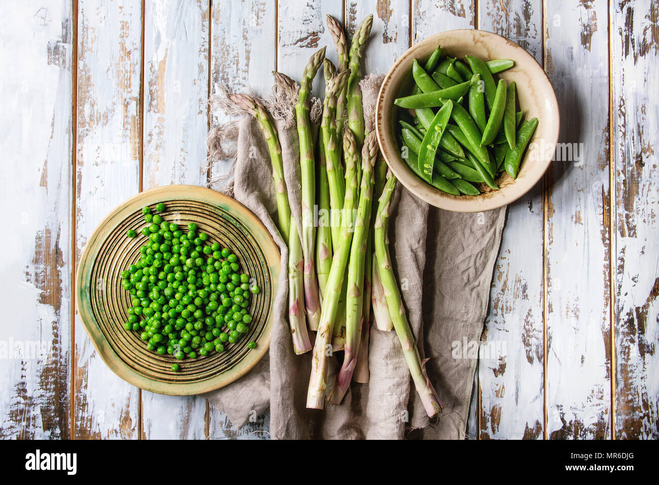 Variety of raw uncooked organic young green vegetables asparagus, peas