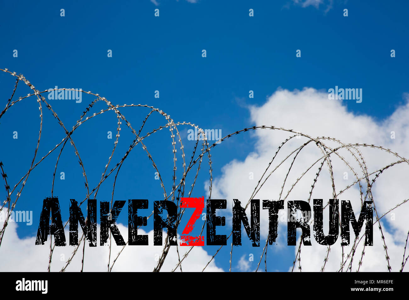 Digital composing, barbed wire with the lettering Ankerzentrum in front of cloudy blue sky Stock Photo