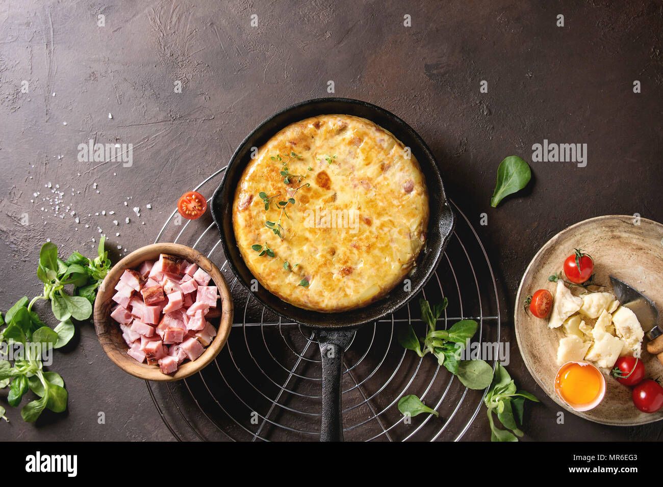 Spanish potato omelette tortilla with bacon served in castiron pan on