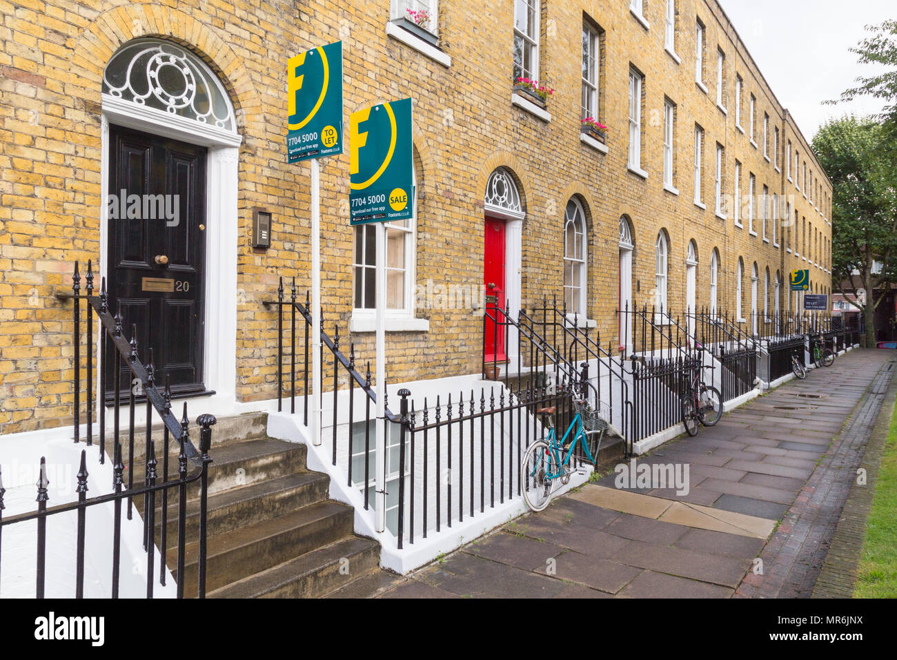 Terraced facades with For Sale signs of Tibberton Square in Islington