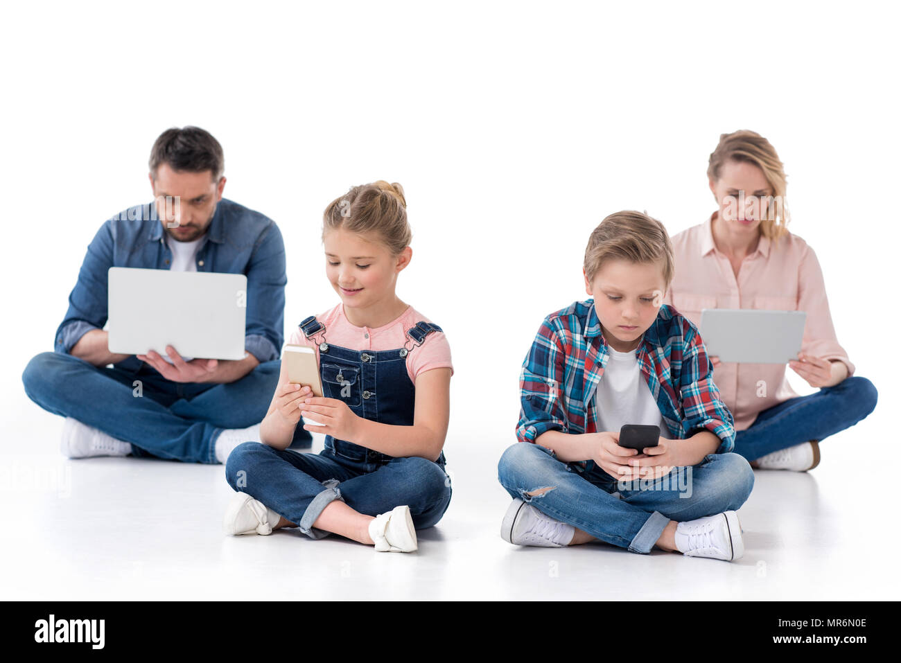 family using smartphones, digital tablet and laptop isolated on white ...