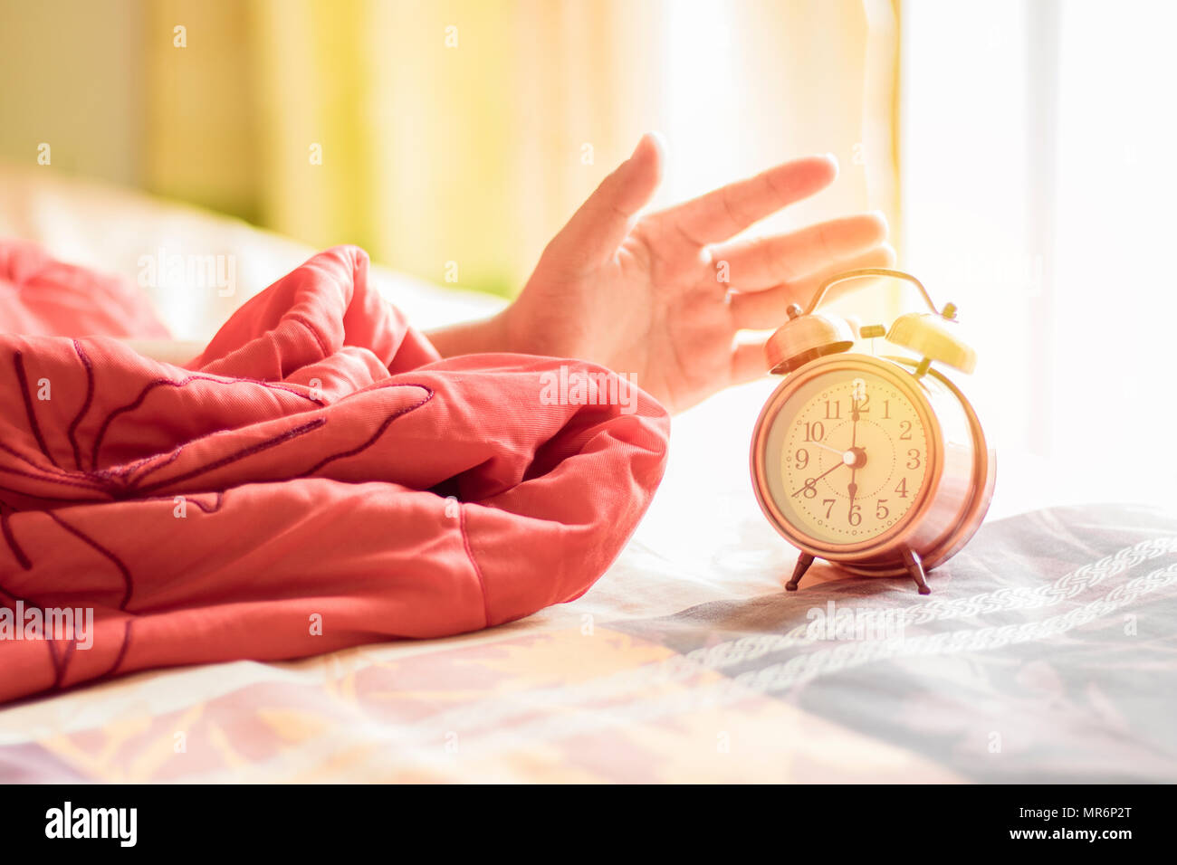 hand stop alarm clock on bed at 6 o'clock Stock Photo Alamy