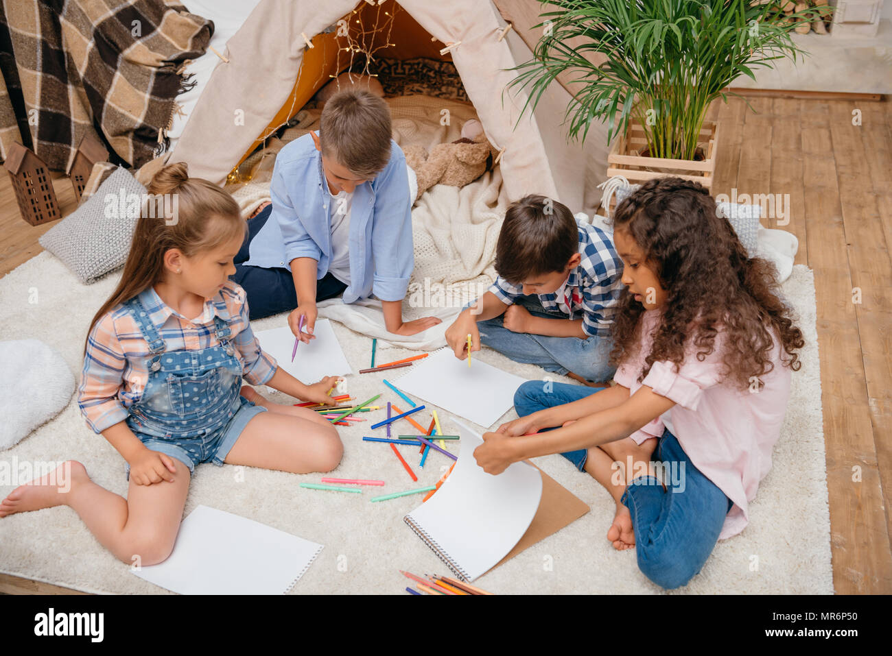 multiethnic group of kids drawing pictures with pencils at home Stock ...
