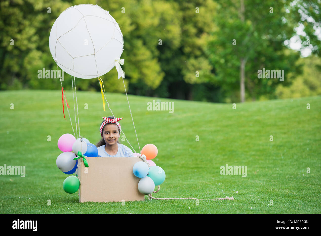 Adorable little african american girl playing with diy hot air balloon in  park Stock Photo - Alamy