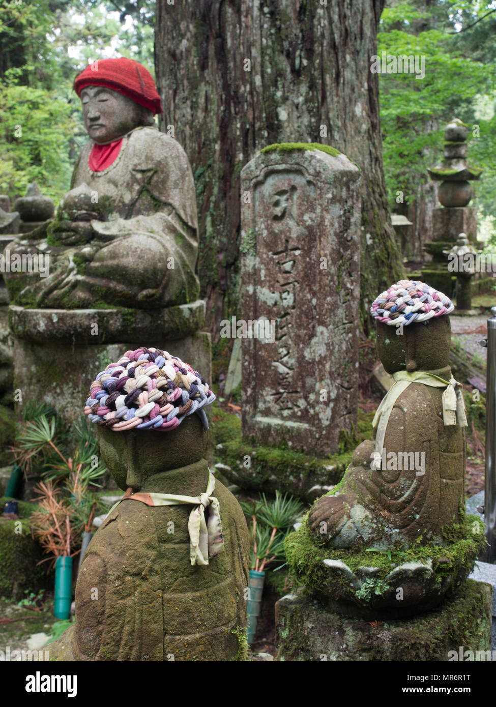 Jizo Bosatsu statues and gorinto five-tiered stupa, and memorial gravestone, with giant sugi tree,  Okunoin, Koya-san, Wakayama Prefecture, Japan Stock Photo