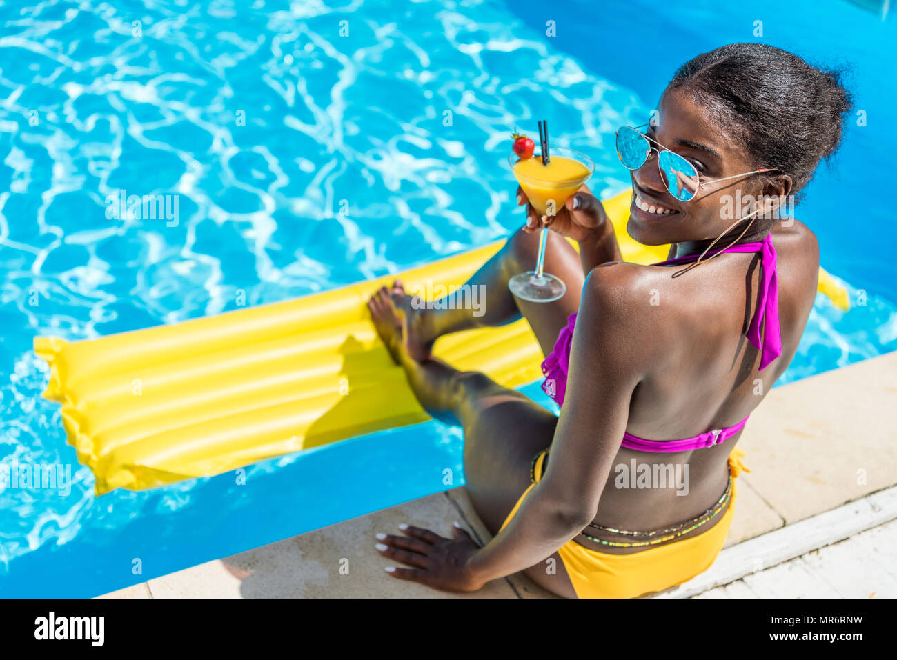 African American Woman Resting With Cocktail Near Swimming Pool At Resort Stock Photo Alamy