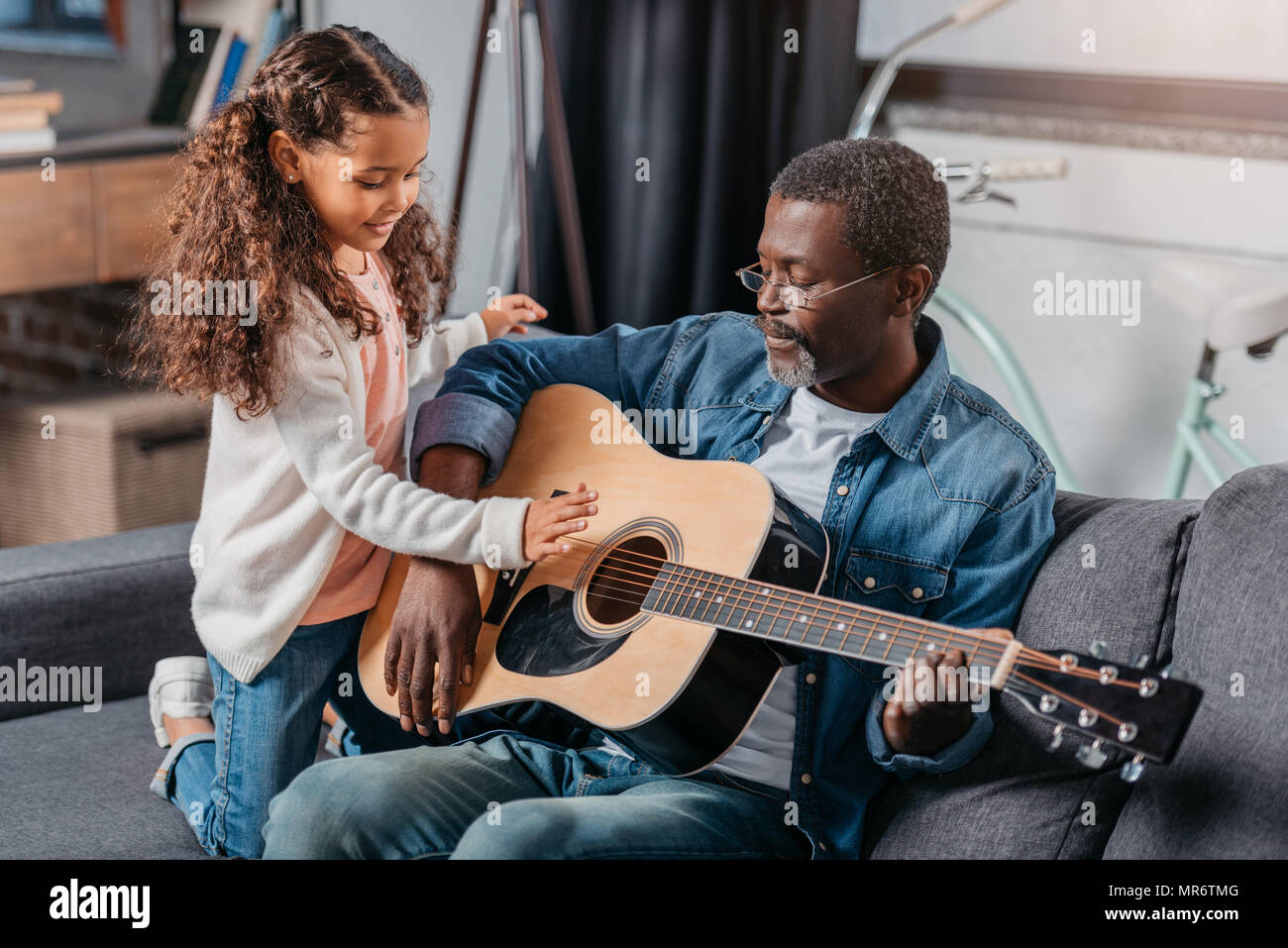 African american man playing guitar with his cute daughter Stock Photo ...