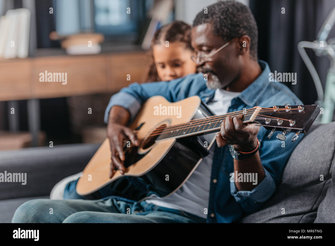 African american man playing guitar with his cute daughter Stock Photo ...