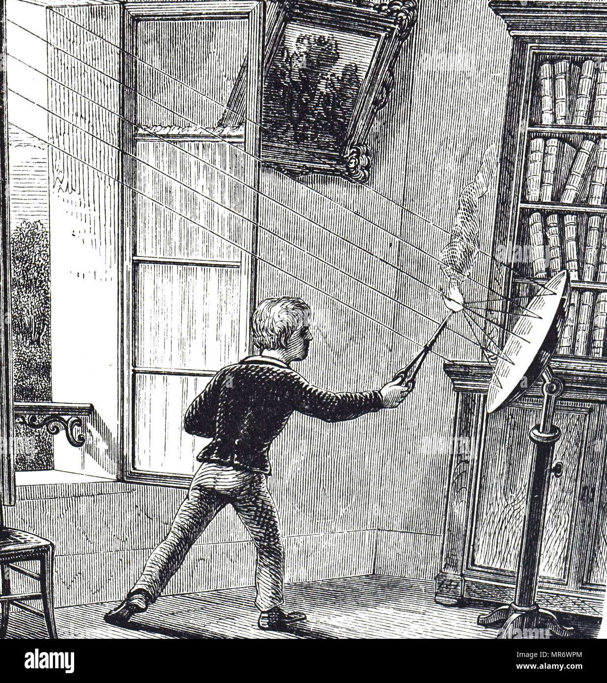Engraving depicting a boy lighting paper using the sun's rays focused by a concave mirror. Dated 19th century Stock Photo