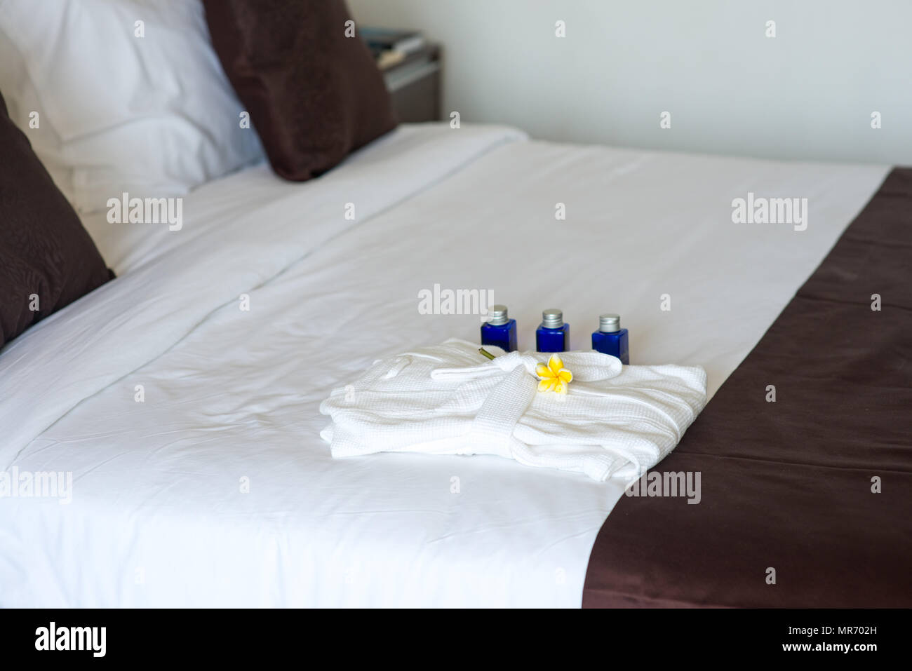 bathroom amenities with bathrobe on bed in hotel room Stock Photo Alamy