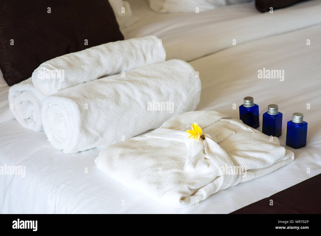rolled towels and bathrobe on bed in hotel room Stock Photo Alamy