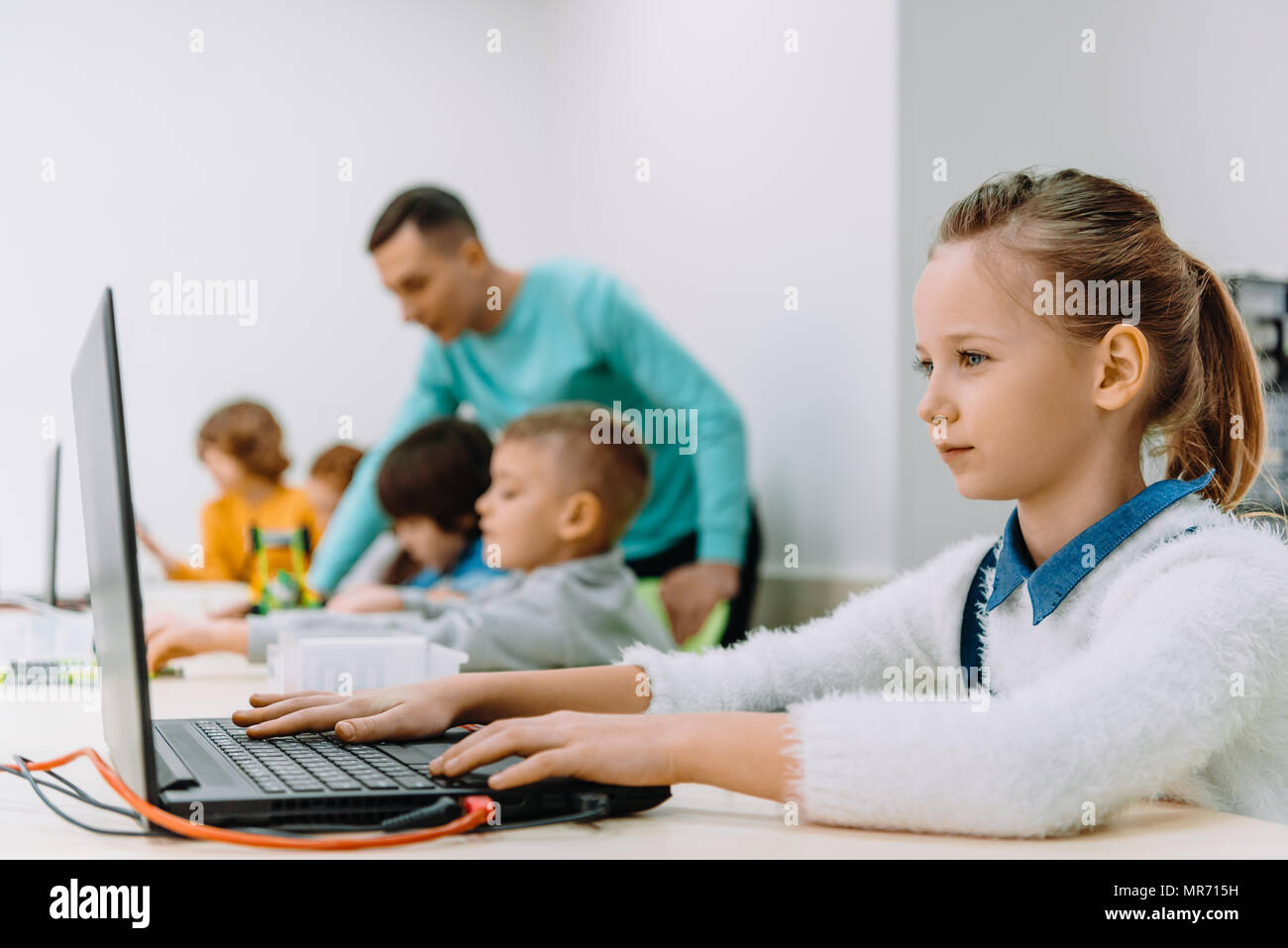 beautiful schoolgirl working with laptop at class, stem education ...