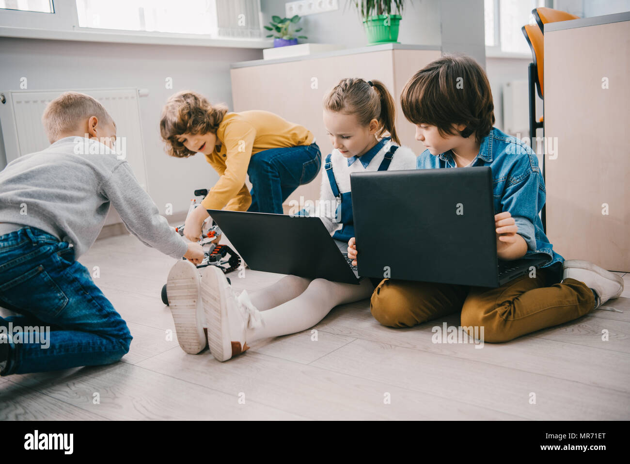 happy kids working with laptops on floor, stem education concept Stock ...