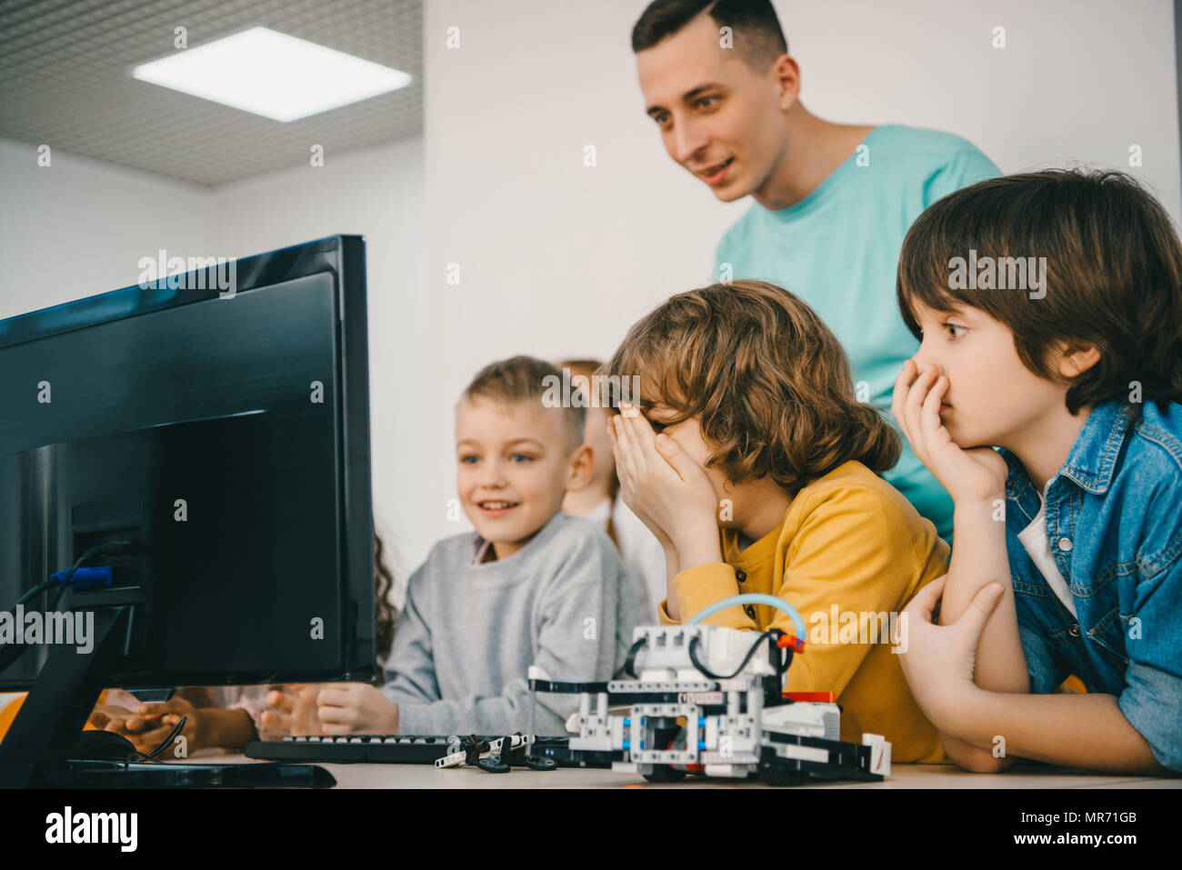 teacher programming robot with his teen students Stock Photo - Alamy