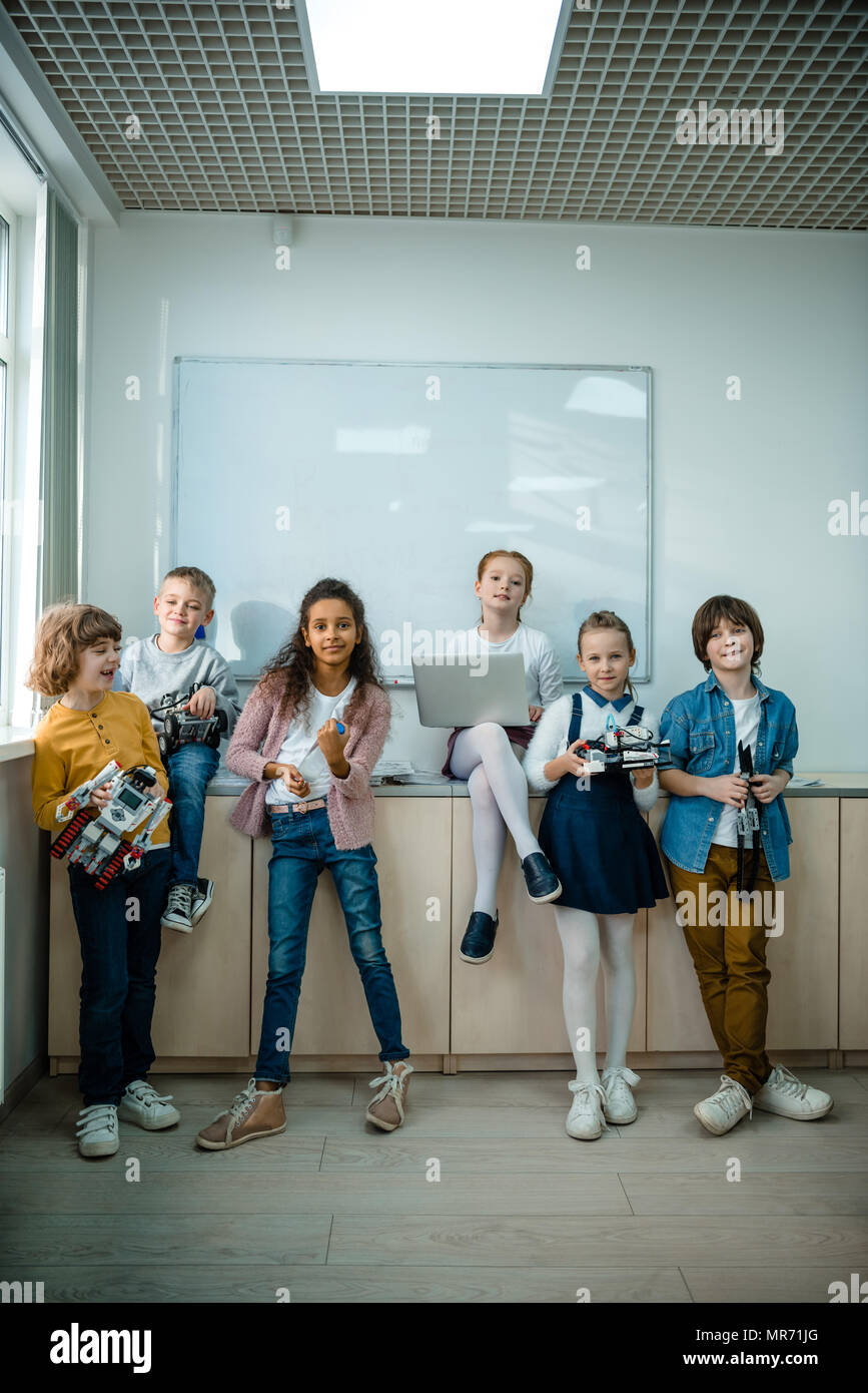 group of kids posing together with laptop and robots on stem education