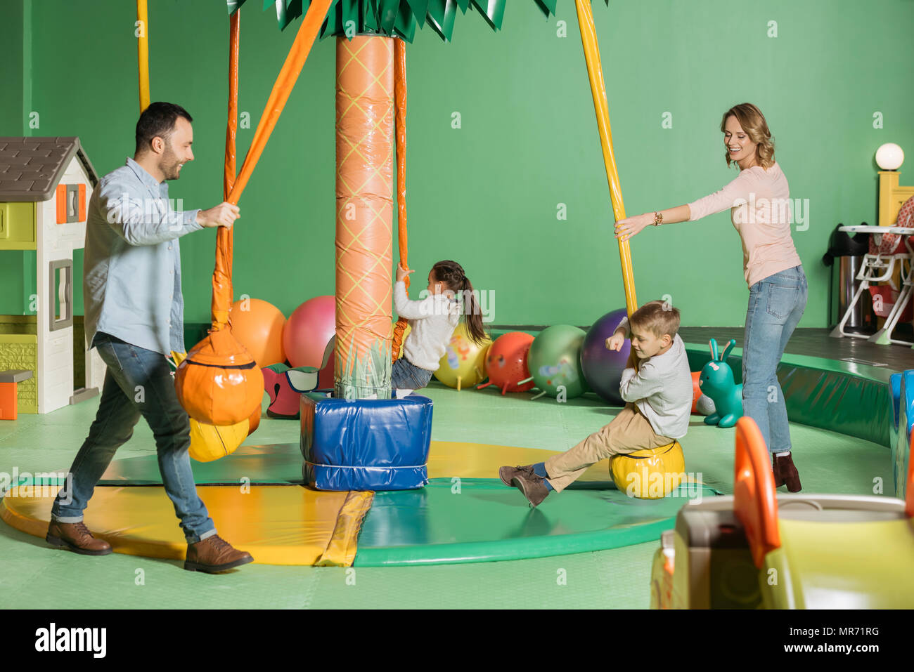 Smiling Parents Looking At Happy Kids Swinging On Swings In Indoor Play Center Stock Photo Alamy Smiling Parents Looking At Happy Kids Swinging On Swings In Indoor Play Center Stock Photo Alamy