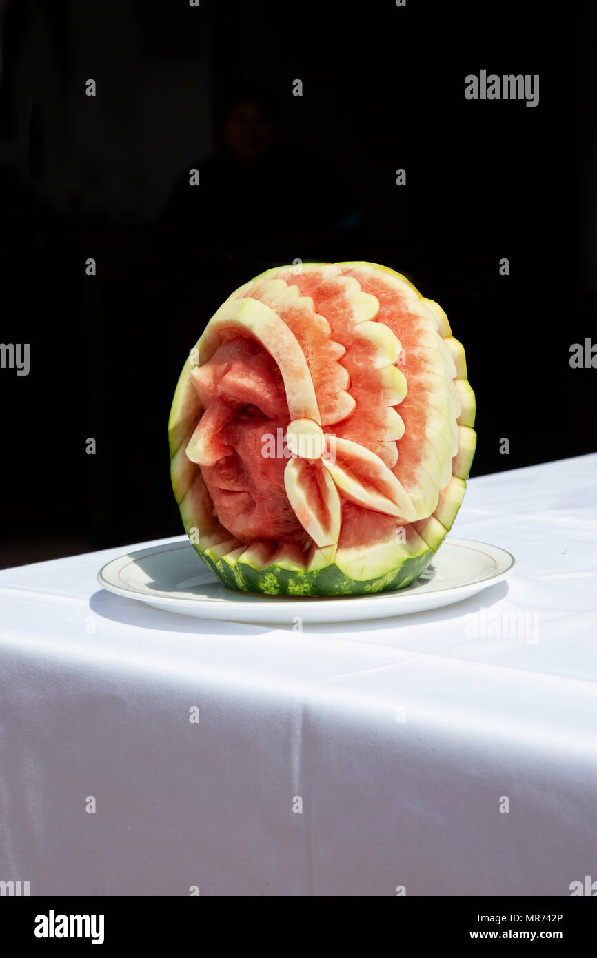 Sculpture of a red Indian with head-dress carved from a watermelon fruit, Cucurbitales. Stock Photo