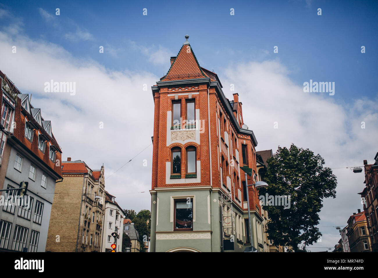 view of city street with colorful buildings and cloudy sky in stuttgart ...
