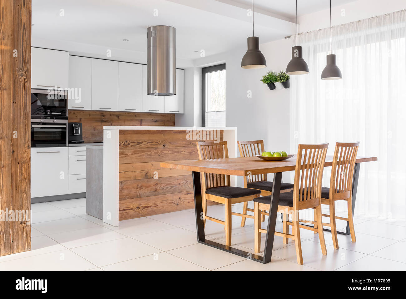 White kitchen with island, table and chairs Stock Photo Alamy