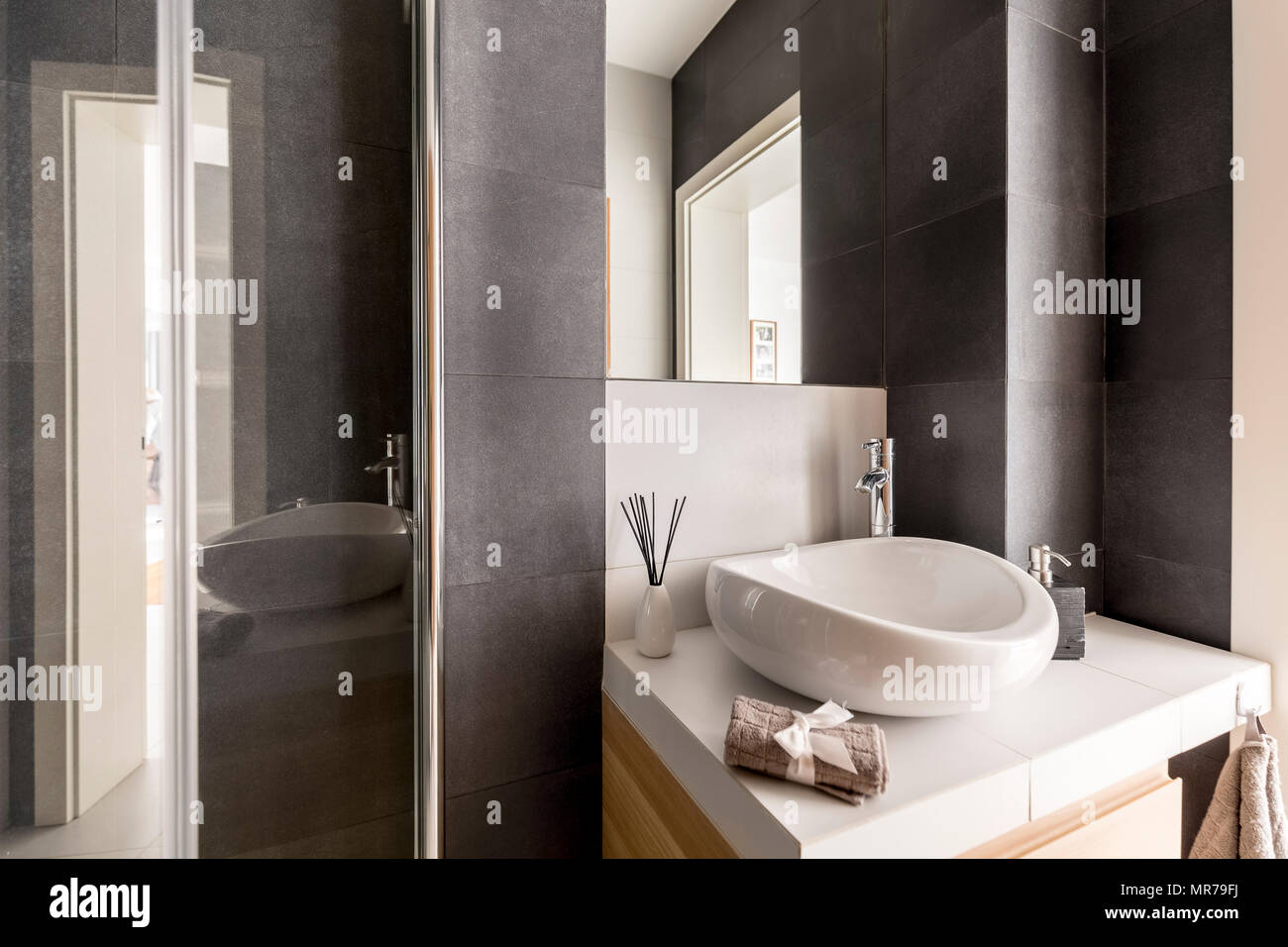 Grey bathroom with white washbasin and mirror Stock Photo