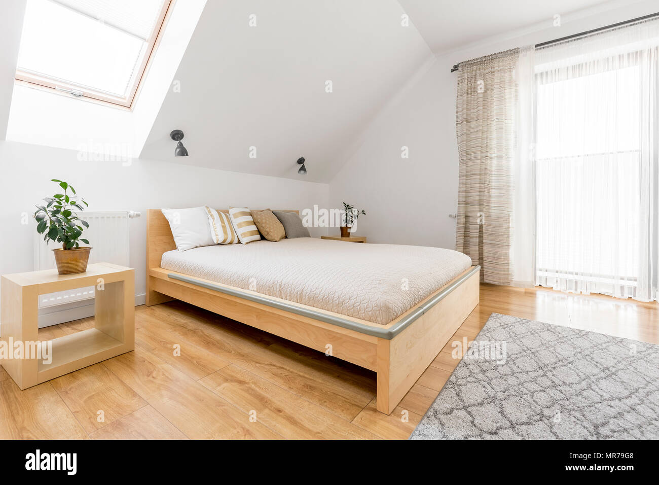 Bright Attic Bedroom With Wood Double Bed And Floor Panels Stock
