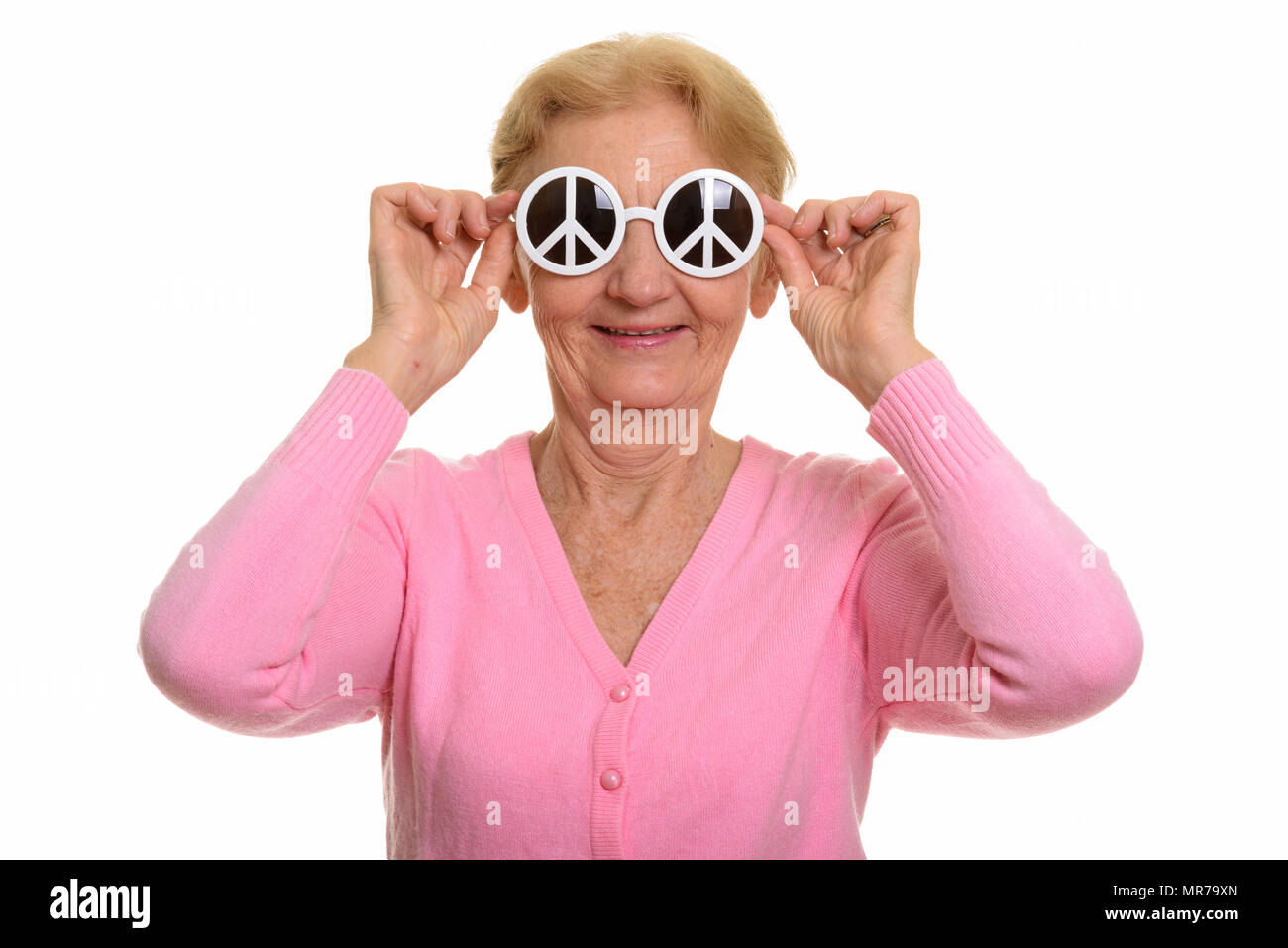 Happy senior woman smiling while holding sunglasses with peace s Stock Photo