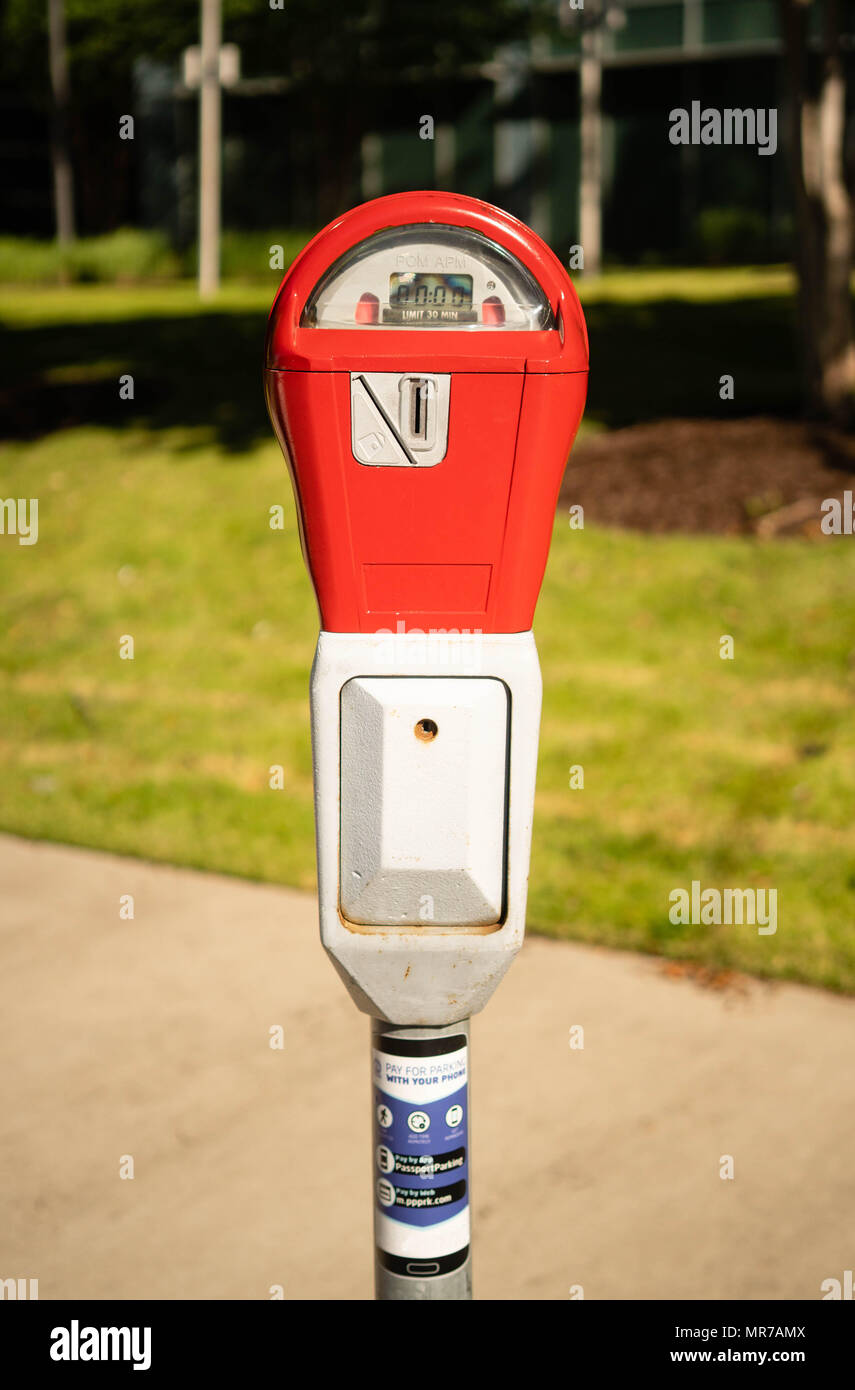 A coin operated parking meter has no time left on a downtown urban sidewalk Stock Photo