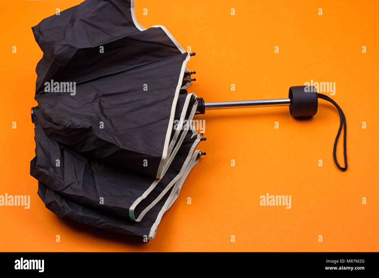 closed black umbrella on the orange background Stock Photo Alamy