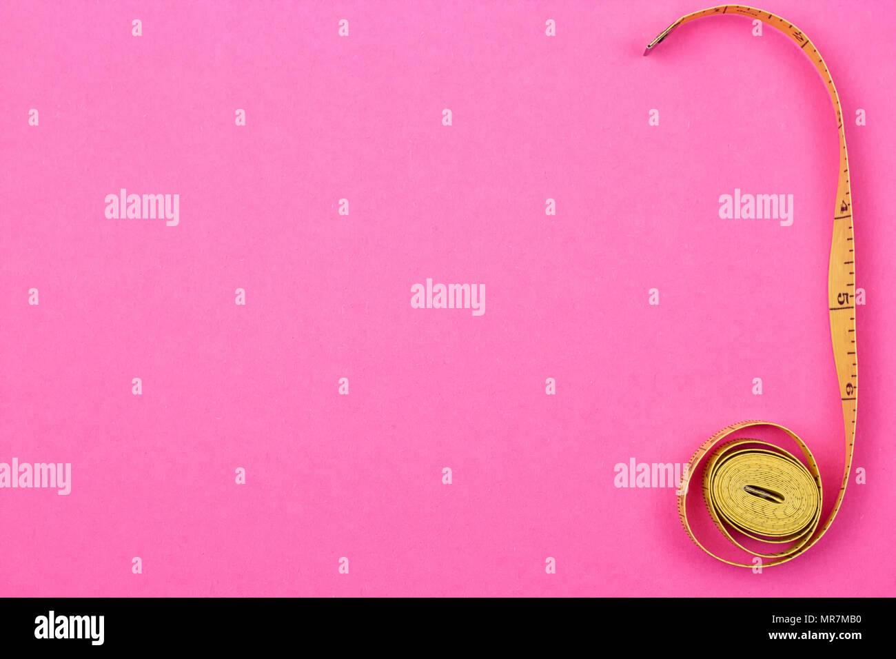 Measuring tape of the tailor on the pink background Stock Photo - Alamy