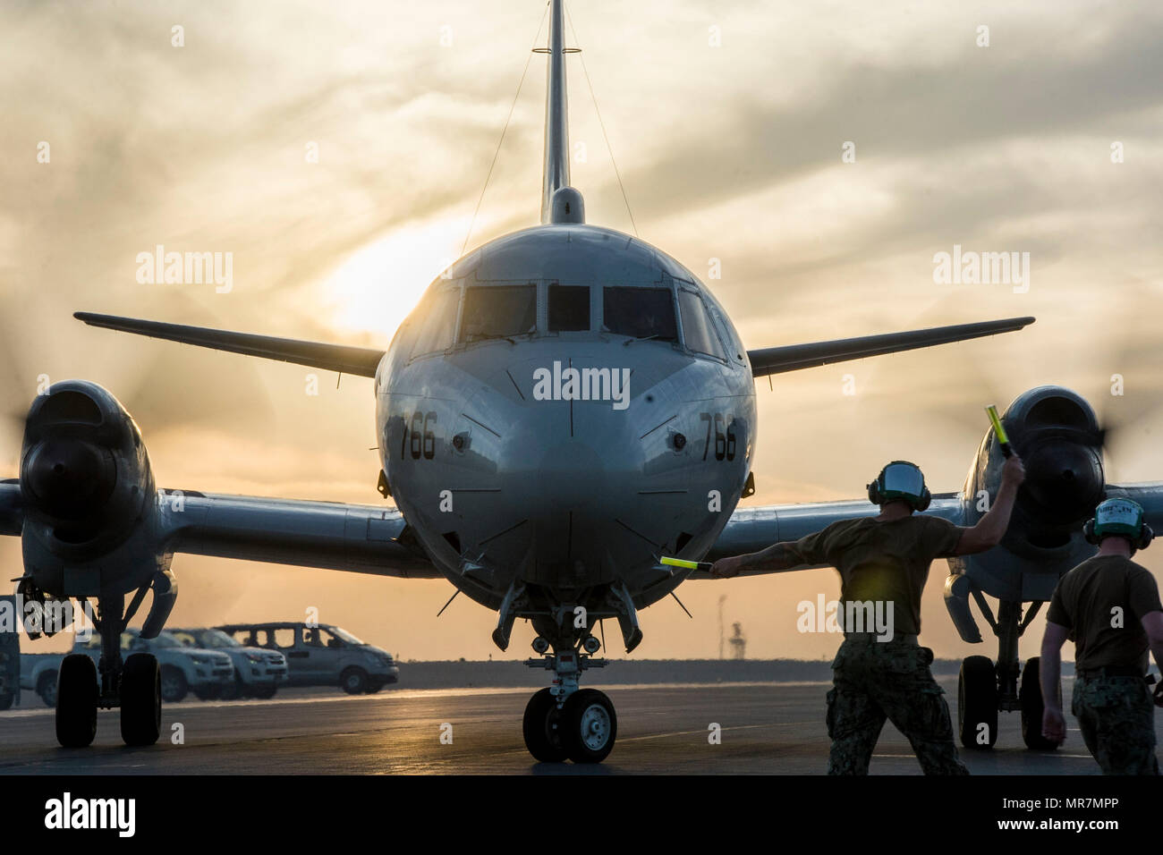 DOHA, Qatar (May 6, 2017) Aviation Structural Mechanic 2nd Class Nathan Tharas of Patrol Squadron (VP) 46 directs a P-3C Orion aircraft as it backs into its parking spot aboard Al Udeid Air Base. VP-46 is currently deployed in the 5th, 6th and 7th Fleet areas of responsibility in support of Operation Inherent Resolve and Restoring Hope. (U.S. Navy photo by Mass Communication Specialist 3rd Class Alex Cole/Released) Stock Photo