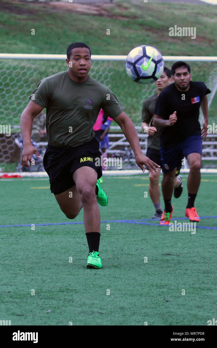 A Paratrooper assigned to 1st Battalion, 508th Parachute Infantry Regiment, 3rd Brigade Combat Team, 82nd Airborne Division, runs to gain ball possession during an All American Week 100 soccer match at Towle Stadium, Fort Bragg, N.C., May 23, 2017. During All American Week 100, Paratroopers from throughout the Division competed in softball, soccer, flag football, tug-of-war, combatives, boxing, a best squad competition, a combat fitness test and the Little Group of Paratroopers competition for bragging rights and a shot at “Best Battalion.” All American Week is an opportunity for Paratroopers, Stock Photo