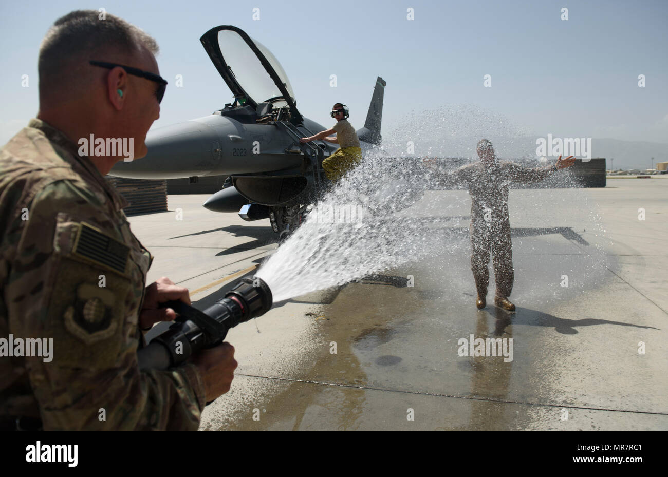 Chief Master Sgt. Peter Speen, command chief of the 455th Air Expeditionary Wing, hoses down Brig. Gen. Jim Sears at Bagram Airfield, Afghanistan, May 22, 2017. Sears, commander of the 455th AEW, conducted his fini flight out of Bagram Airfield. The fini flight is a time-honored military aviation tradition marking the last flight of a commander's tour. (U.S. Air Force photo by Staff Sgt. Benjamin Gonsier) Stock Photo