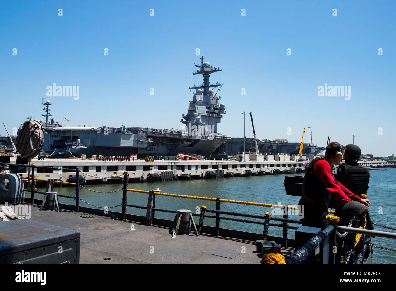 170519-N-QN175-020 NORFOLK, VA. (May 19, 2017) Sailors stand watch on the fantail of the aircraft carrier USS Dwight D. Eisenhower (CVN 69) as the ship gets underway and pulls away from a pier at Naval Station Norfolk. USS Gerald R. Ford (CVN 78) remains moored at the pier.  Dwight D. Eisenhower got underway to conduct engineering drills as part of the sustainment phase of the Optimized Fleet Response Plan. (U.S. Navy photo by Mass Communication Specialist 3rd Class Dartez C. Williams/Released) Stock Photo