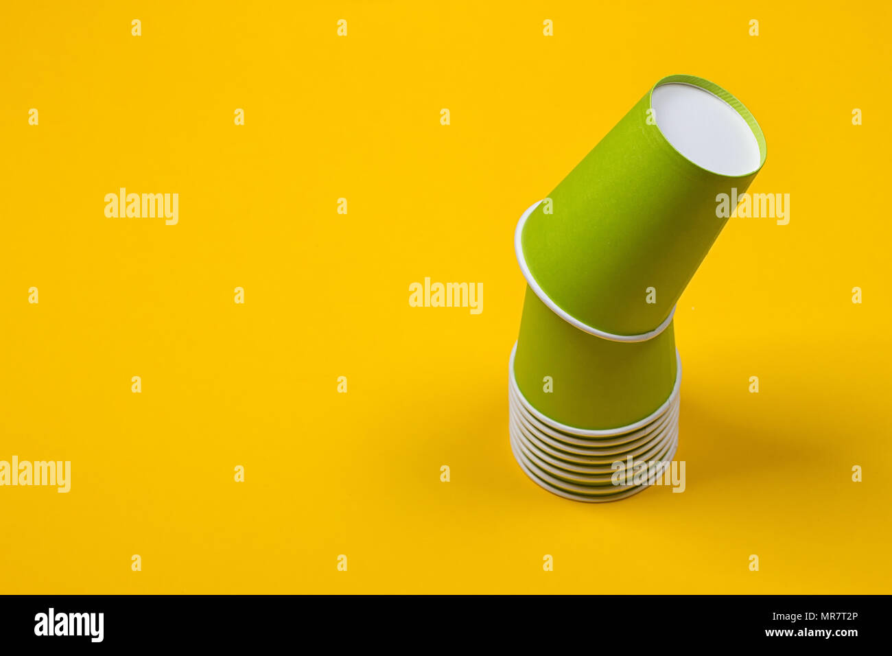 Set of green paper cups on a yellow background Stock Photo - Alamy
