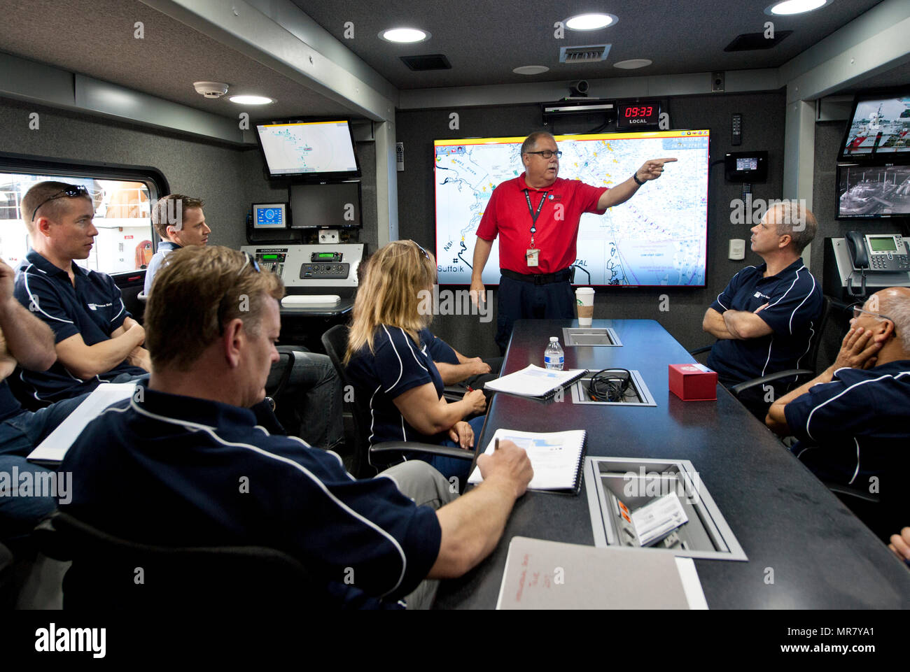 William Burket, director of emergency operations at the Virginia Port Authority in Norfolk, Virginia, explains the capabilities of the Port Authority Command 1 (PAC-1) to students from Queensland University of Technology in Brisbane, Queensland, Australia during their tour of Coast Guard Sector Hampton Roads in Portsmouth, Virginia, May 25, 2017. Burket described how the Coast Guard utilizes PAC-1 during interagency response operations. (U.S. Coast Guard photo by Petty Officer 3rd Class Corinne Zilnicki/Released) Stock Photo
