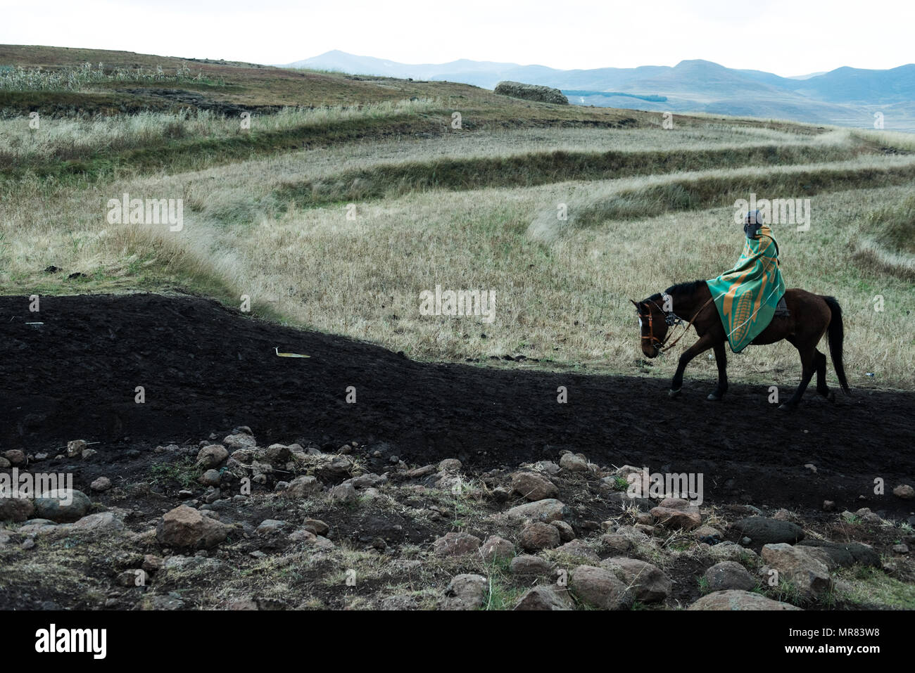 A lone horseman in the mountains of Lesotho near Semonkong Stock Photo