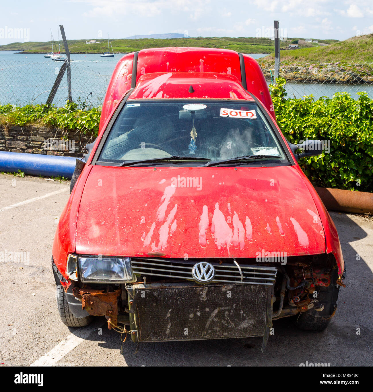 wrecked volkswagen car which has been sold waiting to be collected for spare parts. Stock Photo