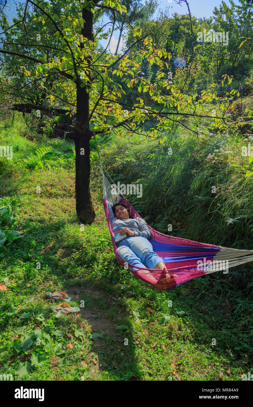 A lady relaxing in hammock - photographed at Tirthan Valley (Himachal Pradesh) Stock Photo