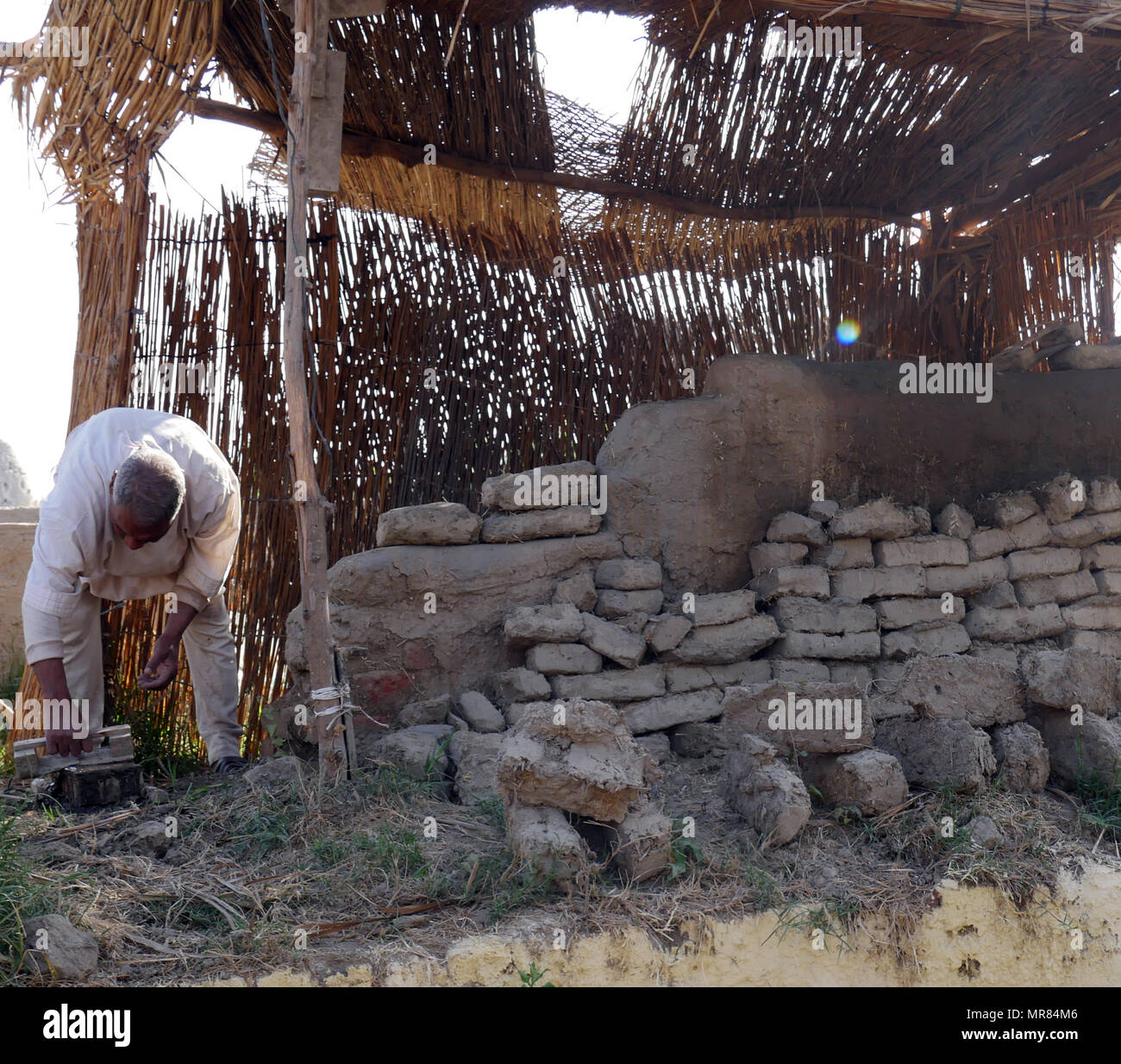 Reenactment of an ancient Egyptian, brick maker, preparing bricks for