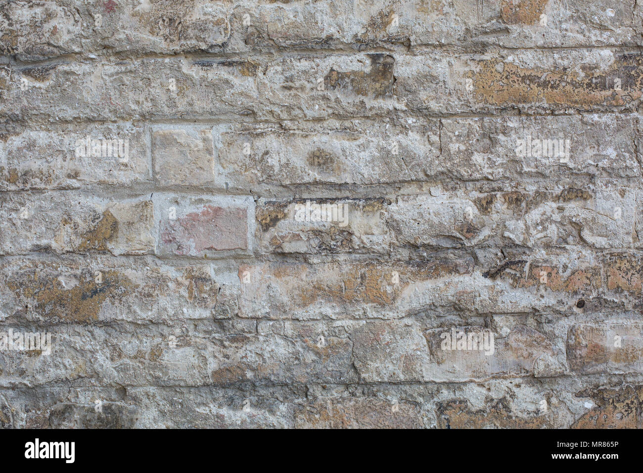 Old wall made of big stones and broken bricks. Vintage rough blocks surface background Stock