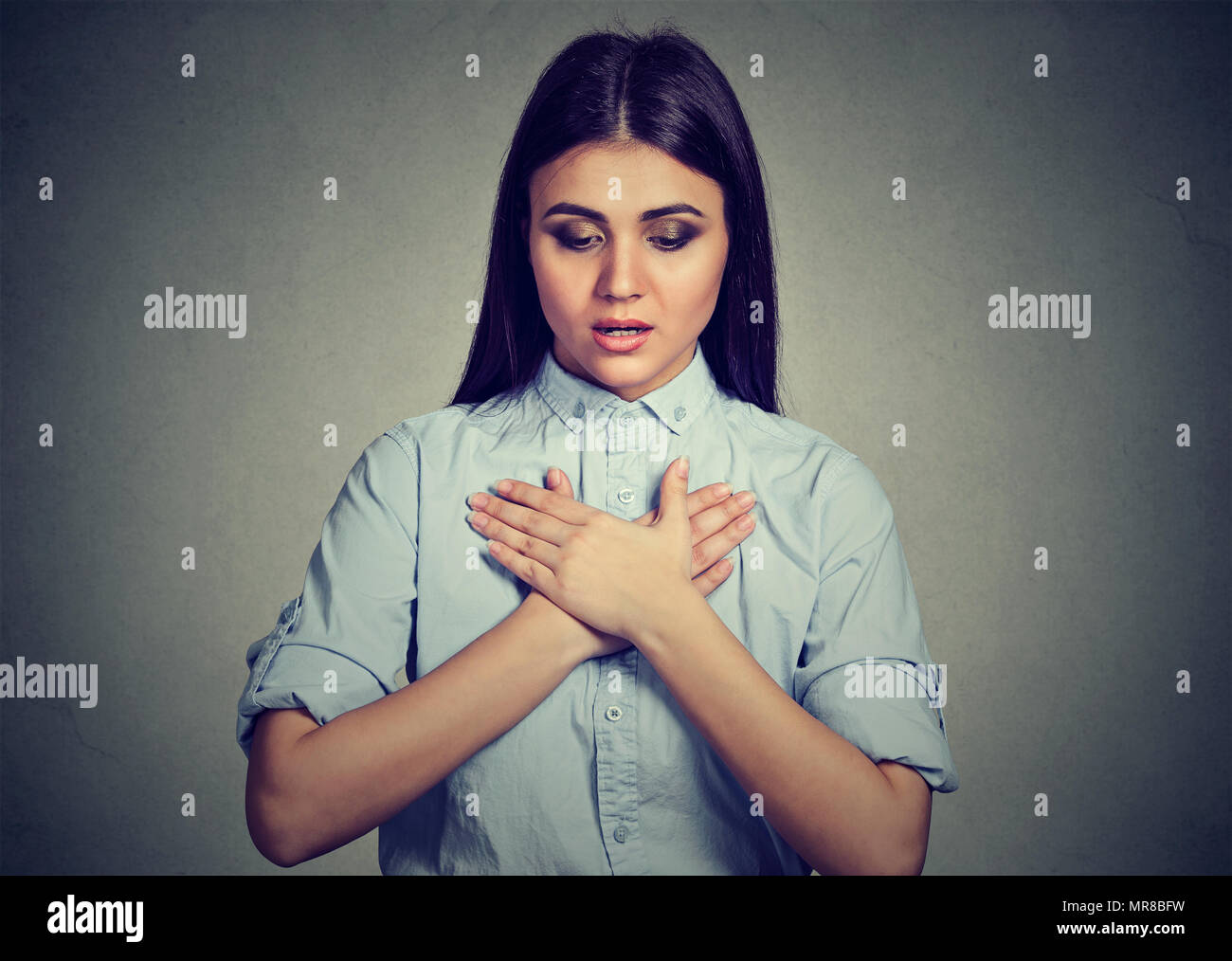 Young woman with asthma attack or respiratory problem isolated on gray background Stock Photo