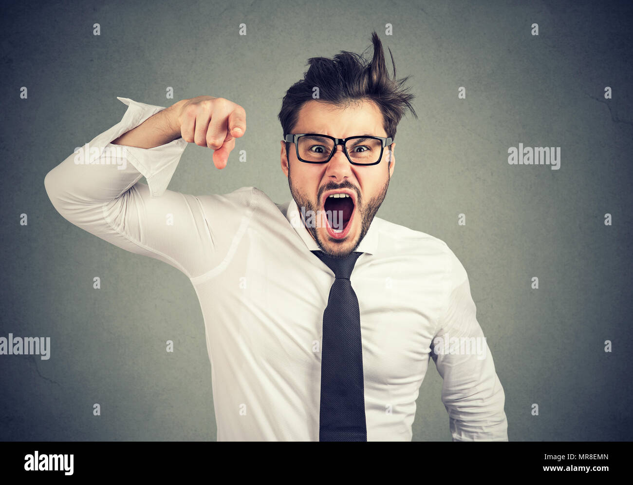 Angry young mad business man accusing someone screaming Stock Photo